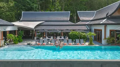 a swimming pool with chairs and a table at Luxurious Villa in Thalang with Private Pool and Ocean Views in Amphoe Thalang