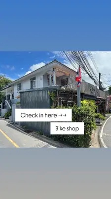 a house on the side of a street with a bike shop at Bike Works Inn Bang Tao in Ban Thalat Choeng Thale