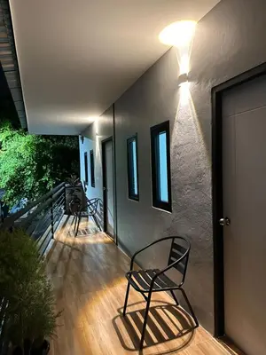 two chairs sitting on a deck with a light on it at Bike Works Inn Bang Tao in Ban Thalat Choeng Thale