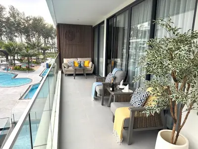 a balcony with furniture and a pool on a building at Sunshine Beach Luxury 3-bedrooms with a great view in Layan Beach