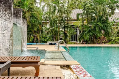 a swimming pool with a bench and a fountain at Tree Resort Palai v2 in Chalong