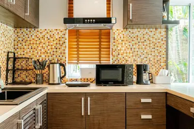a kitchen with a microwave and a stove top oven at Tree Resort Palai v2 in Chalong