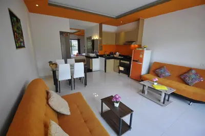 a living room with a couch and a table at Duangjai Residence, Rooms & Apartments in Rawai Beach