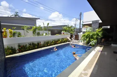 a group of people swimming in a swimming pool at Duangjai Residence, Rooms & Apartments in Rawai Beach