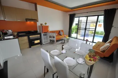 a kitchen and living room with a glass table and chairs at Duangjai Residence, Rooms & Apartments in Rawai Beach
