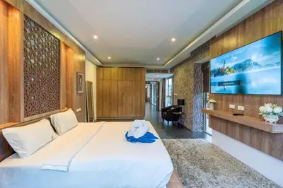 a bedroom with a large white bed and a tv at New Primrose Pool Villa Your Own Secluded Paradise in Rawai Beach