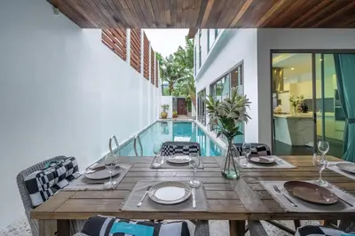 a dining room with a table and a swimming pool at New Primrose Pool Villa Your Own Secluded Paradise in Rawai Beach