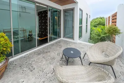 a patio with two chairs and a table on a balcony at New Primrose Pool Villa Your Own Secluded Paradise in Rawai Beach