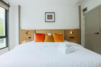 a bedroom with a large white bed with orange pillows at Wink Hill 1 Penthouse Patong 4 Bedrooms in Patong Beach