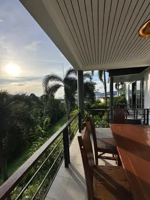 a porch with a table and chairs on a balcony at Quiet Seaview House 1 Bedroom Patong in Patong Beach