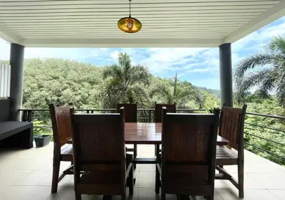 a dining room with a table and chairs on a balcony at Quiet Seaview House 1 Bedroom Patong in Patong Beach
