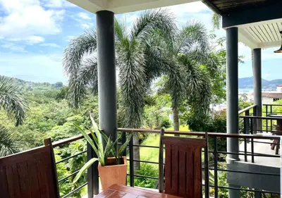 a view from the balcony of a house with palm trees at Quiet Seaview House 1 Bedroom Patong in Patong Beach