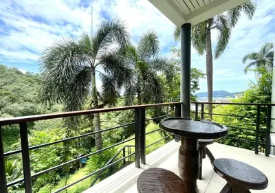 a balcony with a table and two chairs and a view at Quiet Seaview House 1 Bedroom Patong in Patong Beach