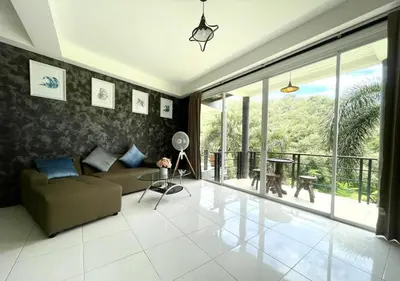 a living room with a couch and a large window at Quiet Seaview House 1 Bedroom Patong in Patong Beach