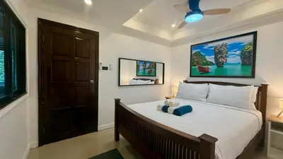 a bedroom with a bed with a teddy bear on it at Palace - Spacious 1 bedroom Condo with shared Pool in Patong Beach