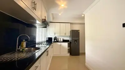 a kitchen with a sink and a refrigerator at Palace - Spacious 1 bedroom Condo with shared Pool in Patong Beach