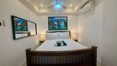 a bedroom with a bed with two shoes on it at Palace - Spacious 1 bedroom Condo with shared Pool in Patong Beach