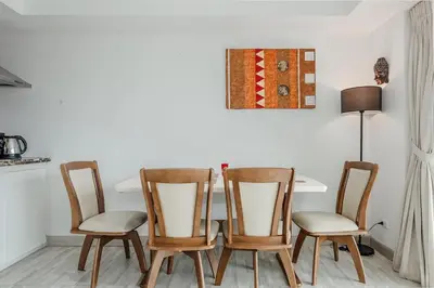 a dining room table with four chairs and a lamp at C236 Best Pool &Sea View 2BR Condo Prime Location in Karon Beach