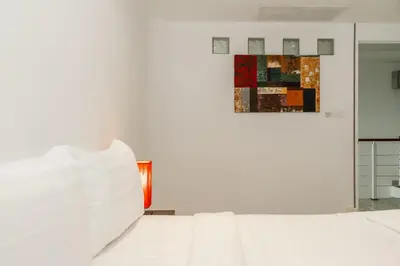 a bedroom with a white bed and a painting on the wall at C236 Best Pool &Sea View 2BR Condo Prime Location in Karon Beach