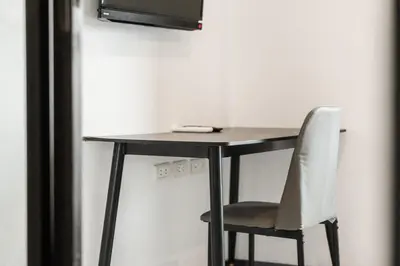 a table with a chair and a television on a wall at C237 Brand New 1BR Condo Pool Gym Near Beach in Bang Tao Beach