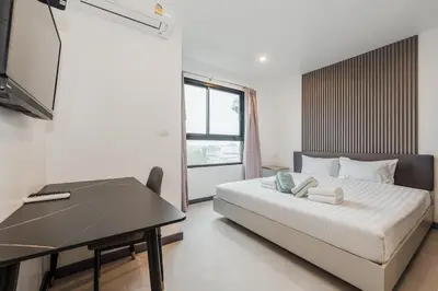 a bedroom with a bed and a desk and a television at C237 Brand New 1BR Condo Pool Gym Near Beach in Bang Tao Beach