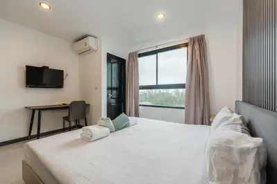 a bedroom with a bed with a window and a desk at C237 Brand New 1BR Condo Pool Gym Near Beach in Bang Tao Beach