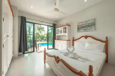 a bedroom with a large bed and a pool at V246 Spacious 4BR Near Pier Private Pool & Garden in Rawai Beach