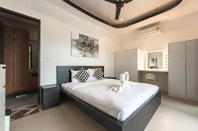 a bedroom with a large bed with white sheets at V246 Spacious 4BR Near Pier Private Pool & Garden in Rawai Beach