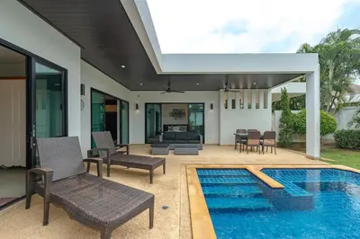 a patio with a pool and chairs and a house at V246 Spacious 4BR Near Pier Private Pool & Garden in Rawai Beach