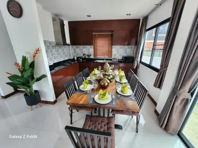 a dining room with a wooden table and chairs at HEART of RAWAI, 4BR Private pool in Rawai Beach