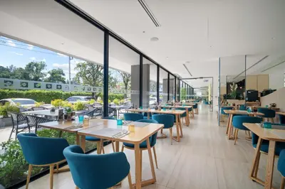 a restaurant with tables and chairs and windows at Pool View Condo 2204 Wyndham Garden Resort in Phuket Town