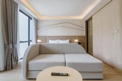 a bedroom with a bed and a couch and a table at Wyndham Gardens Elegant Studio Forrest View 2228 in Phuket Town