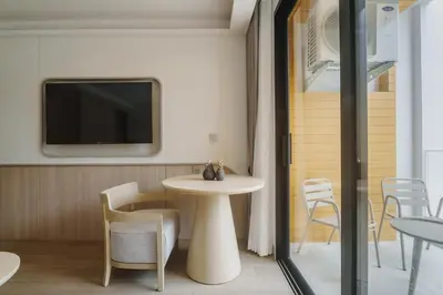 a room with a table and chairs and a tv at Wyndham Gardens Elegant Studio Forrest View 2228 in Phuket Town