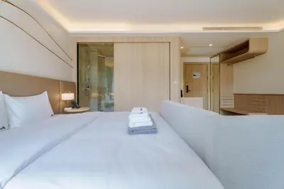 a large white bed in a hotel room at Wyndham Gardens Elegant Studio Forrest View 2228 in Phuket Town