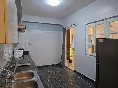 a kitchen with a sink and a door to a window at Moonlight Naka in Ban Rangeng