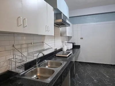a kitchen with a stainless steel sink and white cabinets at Moonlight Naka in Ban Rangeng