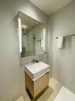 a white bathroom with a sink and a mirror at Daimond resort condominium by koy in Patong Beach