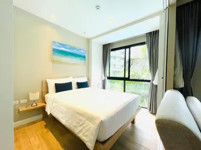 a bedroom with a large white bed and a window at Daimond resort condominium by koy in Patong Beach