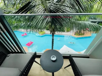 a view of a pool from a room with a palm tree at Daimond resort condominium by koy in Patong Beach