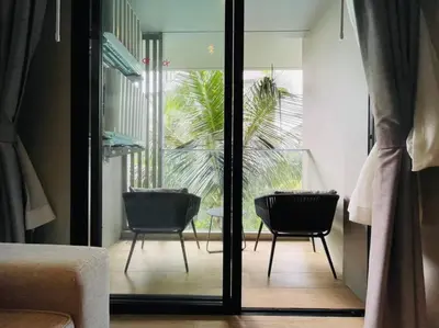 a room with two chairs and a sliding glass door at Daimond resort condominium by koy in Patong Beach
