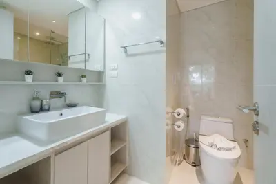 a white bathroom with a sink and a toilet at Cassia Exclusive Lake View Condo Bang Tao Beach in Phuket Town