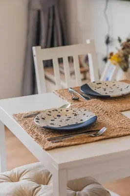 a white table with plates and utensils on it at Apartment Seaview Rooftop Pool Surin beach 650m in Surin Beach