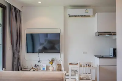 a white room with a tv on the wall at Apartment Seaview Rooftop Pool Surin beach 650m in Surin Beach