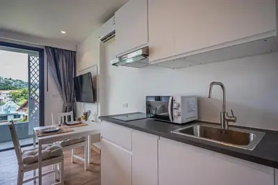 a kitchen with a sink and a counter top at Apartment Seaview Rooftop Pool Surin beach 650m in Surin Beach
