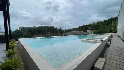 a large swimming pool on top of a building at Sea View Apt with Pool Access at The Quarter 308 in Surin Beach