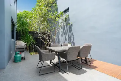 a table and chairs sitting on a patio at Designer Loft Villa Retreat in Pasak, Laguna Area in Ban Pak Lak