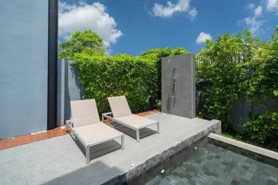 two white chairs and a table next to a pool at Designer Loft Villa Retreat in Pasak, Laguna Area in Ban Pak Lak