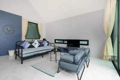 a living room with two couches and a tv at Designer Loft Villa Retreat in Pasak, Laguna Area in Ban Pak Lak