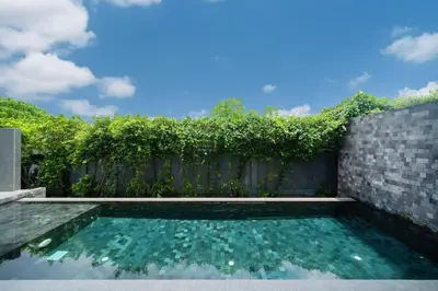 a swimming pool in front of a fence at Designer Loft Villa Retreat in Pasak, Laguna Area in Ban Pak Lak