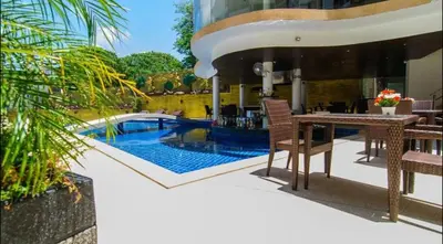 a patio with a table and chairs next to a swimming pool at Bayshore 2 Bedroom Spacious Seaview Apartment in Patong Beach